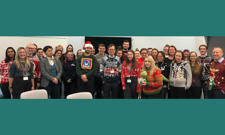 A cropped image of the Newcells team wearing festive jumpers